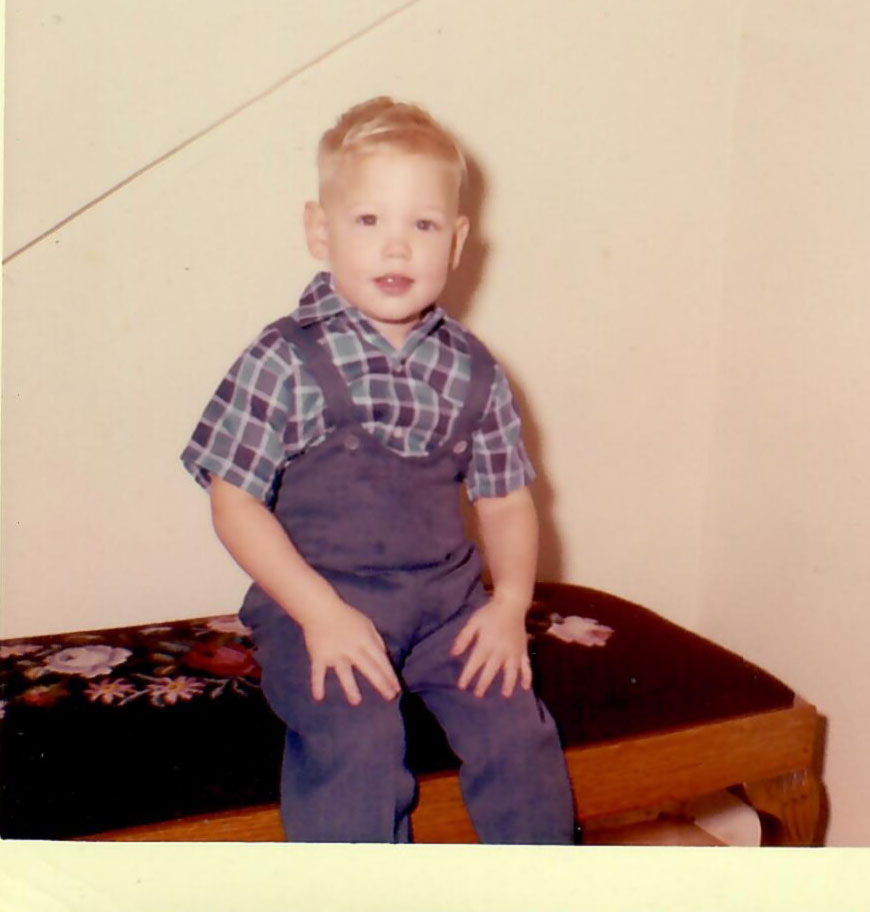 Boyd as a toddler on a bench